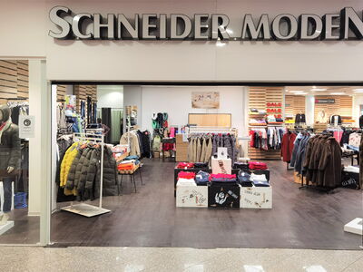 Schaufenster und Innenansicht des Modegeschäfts Schneider Moden mit Bekleidung.